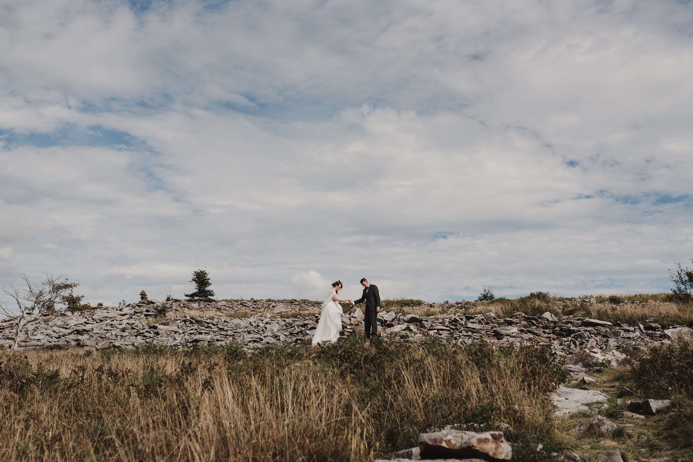 at dolly sods and bride and groom are walking across rocks